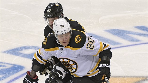 David Pastrk (v blm) z Bostonu jde za pukem, pronsleduje ho Sidney Crosby z Pittsburghu.