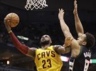 LeBron James (vlevo) z Clevelandu zakonuje akci pes bránícího Malcolma...