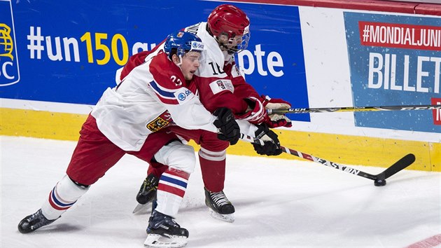 Český hokejista David Kaše bojuje o puk s Dánem Jonasem Rondbjergem.