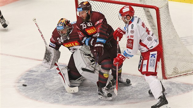 Třinecký hokejista Erik Hrň�a (vpravo) sleduje puk před sparťanskou brankou, hlídanou Tomášem Pöpperlem.