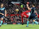 Paul Pogba (v erveném) z Manchesteru United se pokouí o akrobatické zakonení...