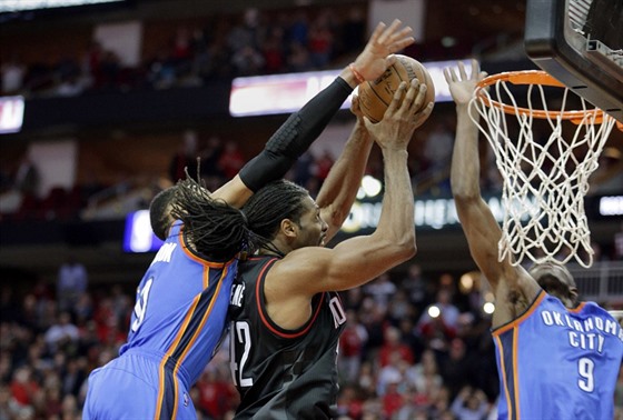 Russell Westbrook a Victor Oladipo z Oklahomy se pokouejí zastavit Neneho z...