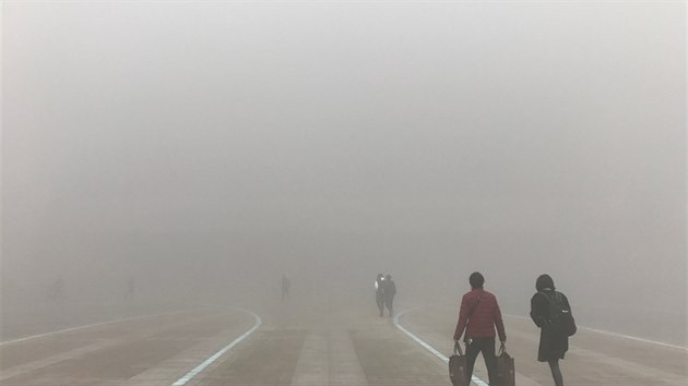 Lid v nskm eng-ou m skrz hust smog na ndra. (9.ledna 2017)