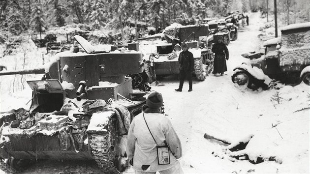 Finští vojáci po bitvě o Suomussalmi obhlíží sovětskou techniku na Raatské cestě. Vpředu jsou dva tanky T-26, za nimi malé obojživelné T-37.