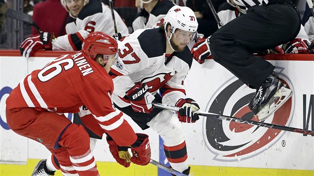 Pavel Zacha z New Jersey (vpravo) a Teuvo Teravainen z Caroliny bojuj o puk.