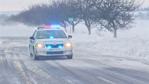 Policie dohlíží na provoz na zasněžených silnicích.