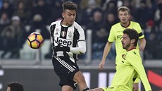 Paulo Dybala z Juventusu st�ílí p�es dva hrá�e Boloni, akci z povzdálí sleduje...