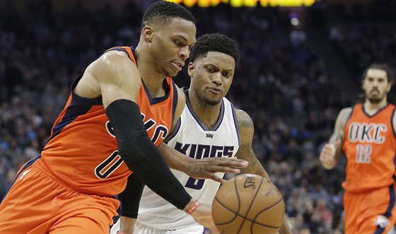 Russell Westbrook (vlevo) z Oklahomy se snaí obejít Rudyho Gaye ze Sacramenta.