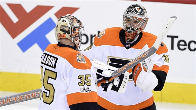 Brank Michal Neuvirth (vpravo) z Philadelphie std kolegu Steva Masona.