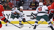 Mikael Granlund z Minnesoty pihrává puk Jasonu Zuckerovi v utkání proti...