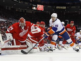Brankář Detroitu Petr Mrázek čelí snaze Nikolaje Kuljomina z New York Islanders.