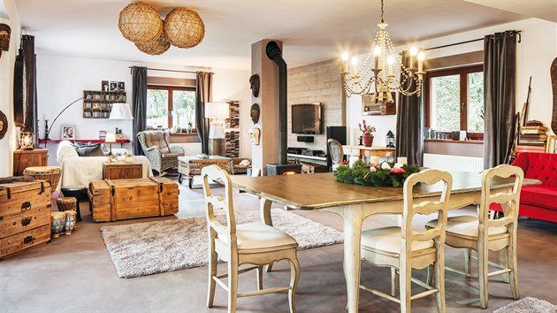 Jídelní stůl se židlemi z masivního dřeva stojí strategicky mezi kuchyní a obývacím pokojem.