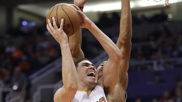 Devin Booker z Phoenixu let ke koi Milwaukee kolem Janise Adetokunba.