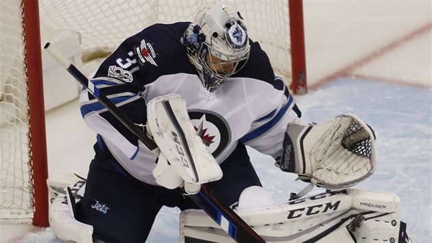 Brank Winnipegu Ondej Pavelec zasahuje v utkn proti Coloradu.