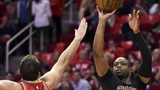 Dwyane Wade (vpravo) z Chicaga stílí pes Ryana Andersona z Houstonu.