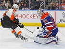 Brank Edmontonu Cam Talbot zasahuje proti Jakubu Vorkovi z Philadelphie.