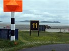 Práh dráhy 11 vyznačený oranžovým markerem.
