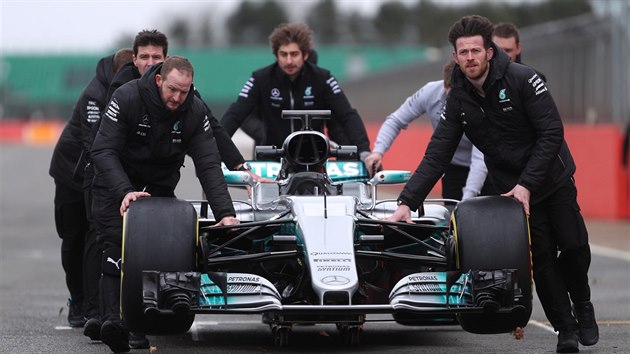 Mechanici tlačí svůj poklad při představování nového monopostu Mercedes pro sezonu 2017 ve formuli 1.