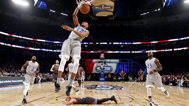 Janis Adetokunbo z tmu Vchodu smeuje v Utkn hvzd NBA. Stephen Curry ze Zpadu se ped jeho bombou radi kryje. Lehl si na palubovku a zacpal si ui.