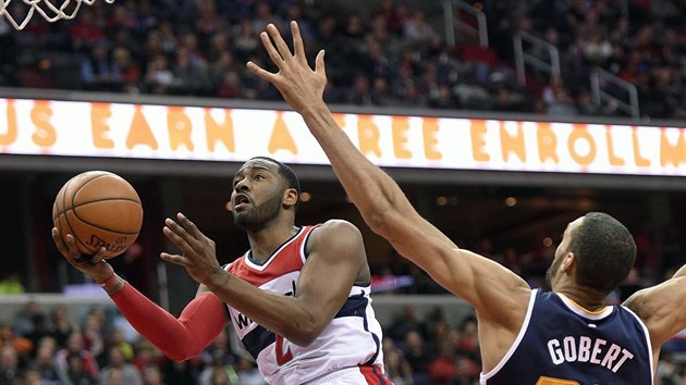 John Wall (vlevo) z Washingtonu atakuje ko Utahu kolem Rudyho Goberta.