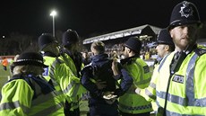 Policisté zatýkají jednoho z fanoušků Suttonu po zápasu s Arsenalem.