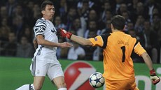 Gólman Porta Iker Casillas odkopává mí ped útoníkem Juventusu Mariem...