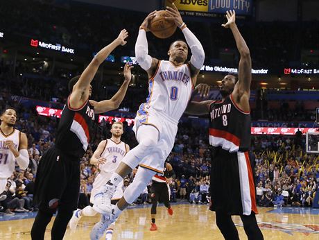 Russell Westbrook - hvzda týmu Oklahoma City -letí na ko Portlandu. Vlevo je...