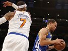 Stephen Curry (v modrém) z Golden State s míem letí kolem Carmela Anthonyho z...