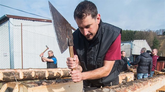 Řemeslníci tesají ve valašské obci Bystřička trámy na obnovu vyhořelé chaty Libušín.