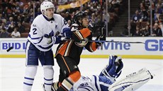 Matt Hunwick z Toronta napadá Rickarda Rakella z Anaheimu, který práv pekonal...