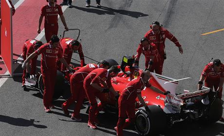 Finský pilot Kimi Räikkönen se svým ferrari v depu bhem testování v Barcelon.