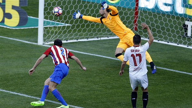 Obrnce Atltika Madrid Diego Godn posl hlavou svj tm do veden nad Sevillou. Jej brank Sergio Rico se za mem natahuje marn.