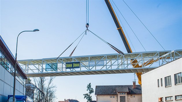 Jeřáb usazuje část mostu, který bude spojovat areály Budějovického Budvaru.