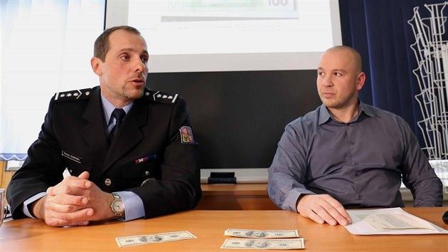 Zleva policisté Robert Kubánek a Petr Molnár předvádějí zadržené falešné bankovky.