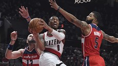 Damian Lillard z Portlandu se pokouí dopravit mí do koe mezi dvojicí Marcin...