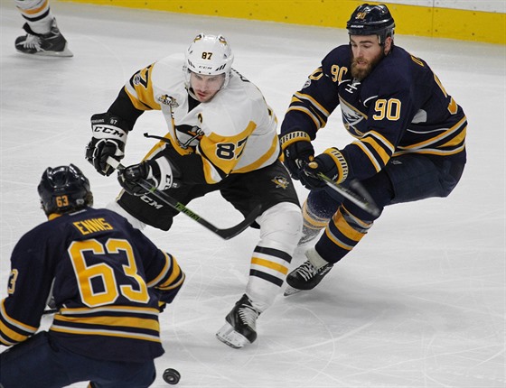 Sidney Crosby z Pittsburghu sleduje puk v obklíení buffalských útoník Tylera...