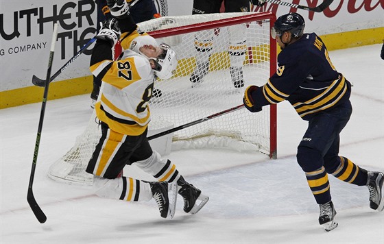 Sidney Crosby z Pittsburghu po zsahu do oblieje od buffalskho Evandera Kanea.