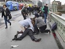 Lidé pomáhají mui, kterého zranil útoník nedaleko budovy britského...