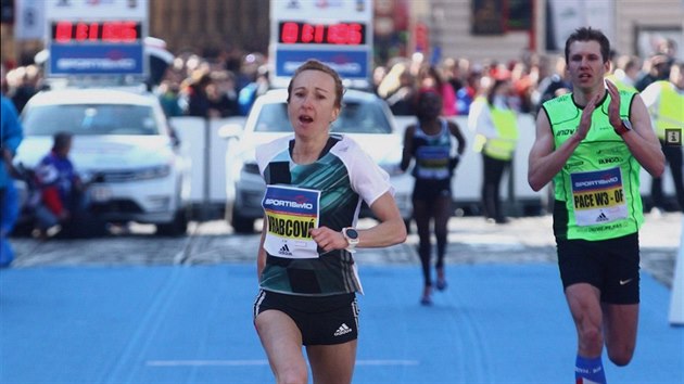 Eva Vrabcová Nývltová v cíli Pražského půlmaratonu v roce 2016. Za ní běží a tleská její vodič Ondřej Fejfar.