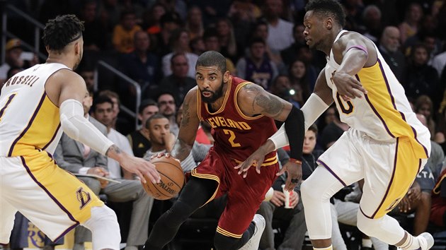 Kyrie Irving (uprosted) z Clevelandu pronik mez D'Angelem Russellem (vlevo) a Juliusem Randlem z LA Lakers.