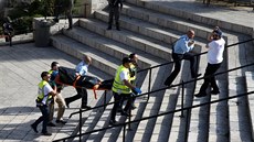 Zdravotníci odná�ejí t�lo zast�elené �eny