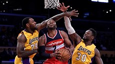 John Wall z Washingtonu úpí mezi Tarikem Blackem (vlevo) Juliusem Randlem z Los...