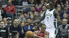 Rajon Rondo (dole) z Chicaga se snaí rozehrát, brání ho Thon Maker z Milwaukee.