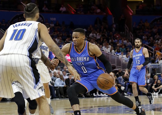 Russell Westbrook (0) z Oklahoma City se ítí kolem  Evana Fourniera z Orlanda.