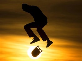 SKATE NA SLUNCI. Skateboardista pedvádí své triky pi  západu slunce v...