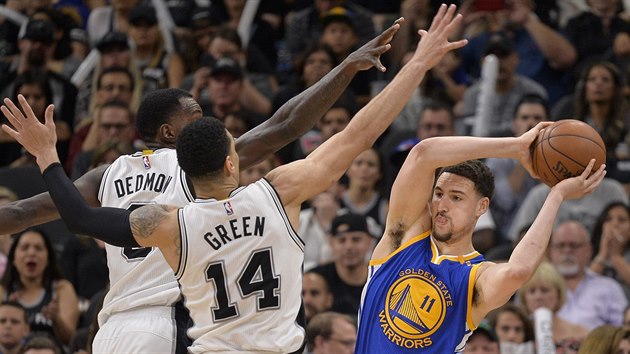 Klay Thompson (11) z Golden State hled prostor pro pihrvku kolem Dannyho Greena a Dewayna Dedmona ze San Antonio.