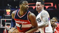 Washingtonský basketbalista John Wall (vlevo) se snaí prosadit pes JJ Redicka...