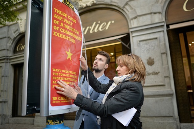 Adriana Krnáčová vyvěšuje plakát upozorňující na problém s nepoctivými taxikáři.