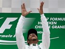 HOP. Lewis Hamilton si hraje s trofejí pro vítze Vellké ceny íny.