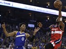 John Wall (vpravo) z Washingtonu zakonuje na ko Golden State, sleduje ho...